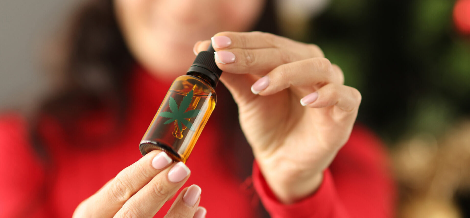 Young,Woman,In,Santa,Claus,Hat,Holding,A,Bottle,With